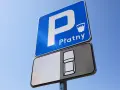 Znak D18 informuje o płatnym parkingu. Widoczny symbol samochodu sugeruje miejsce postojowe.