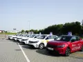Rząd białych i jeden czerwony samochód szkoleniowy z literą "L" na dachu. Zastanawiasz się, ile kosztuje egzamin praktyczny na prawo jazdy?