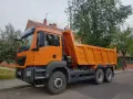 Pomarańczowy wywrotka c1 stoi na ulicy, gotowa do pracy.