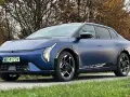 Niebieski Polestar 2 na tle jesiennych drzew. Elegancki samochód elektryczny z charakterystycznymi światłami i felgami.