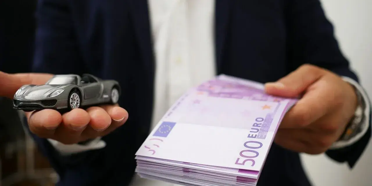 Model samochodu i stos banknotów 500 euro. Symbolizuje to cesję leasingu, gdzie nowy właściciel przejmuje zobowiązania.