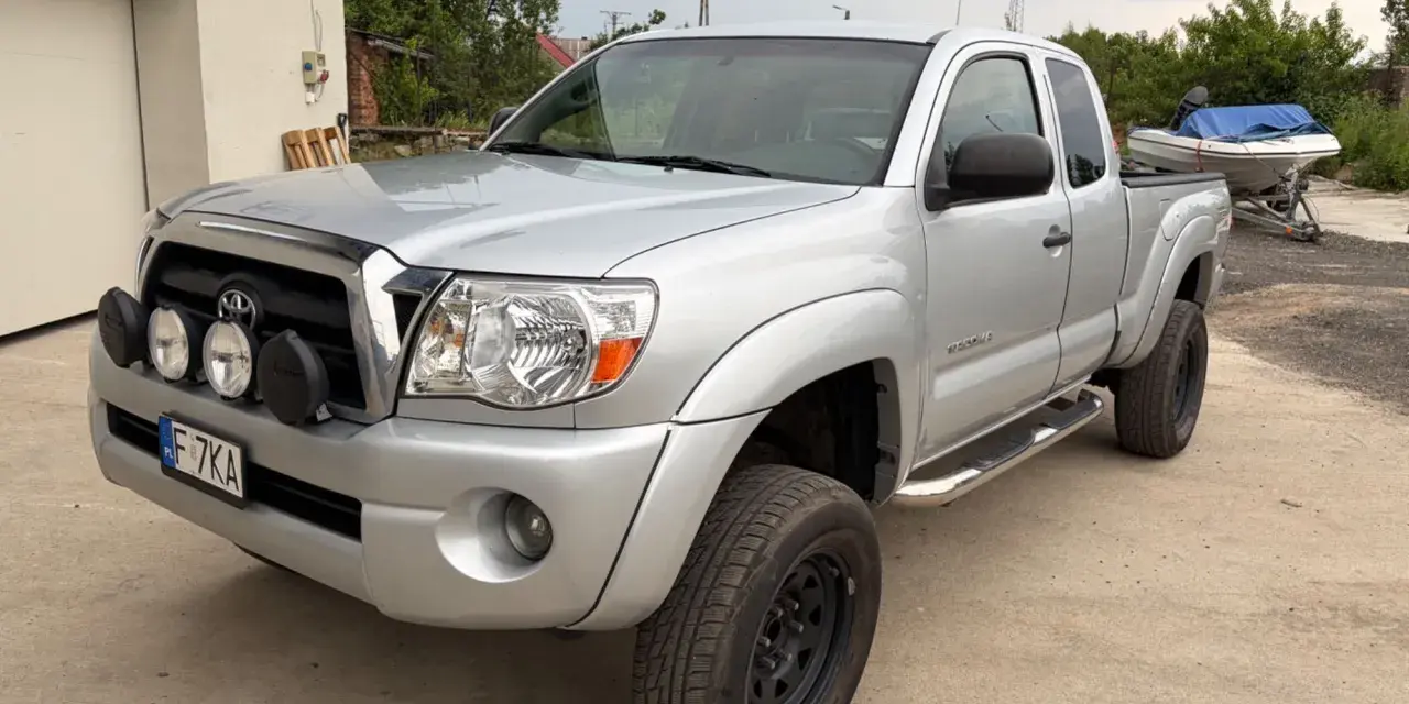Srebrna Toyota Tacoma z dodatkowymi światłami, gotowa na przygodę.