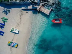 Idealne miejsce, gdzie w styczniu na wakacje: pusta plaża z łódkami i turkusowa woda.