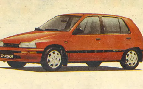 Czerwony Daihatsu Charade z lat 90. na tle jasnego, lekko zszarzałego papieru.