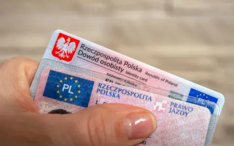Dłoń trzyma polski dowód osobisty i prawo jazdy. To dokumenty, które pozwalają na swobodne podróżowanie, a prawo jazdy bezterminowe daje spokój na lata.