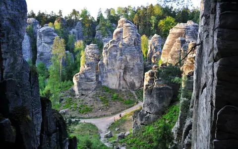 Skalne miasto Adršpach z wąwozami, ścieżkami i drzewami.
