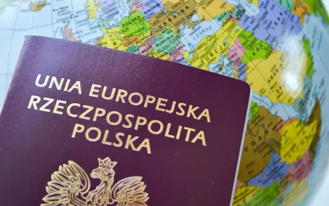 Polski paszport na tle globusa z zaznaczoną Europą.
