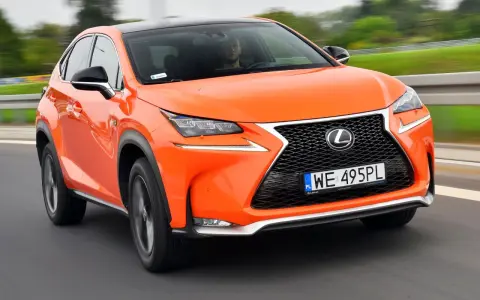 Pomarańczowy Lexus NX 300 jedzie po drodze, kierowca widoczny za kierownicą.