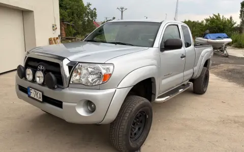 Srebrna Toyota Tacoma z dodatkowymi światłami, gotowa na przygodę.