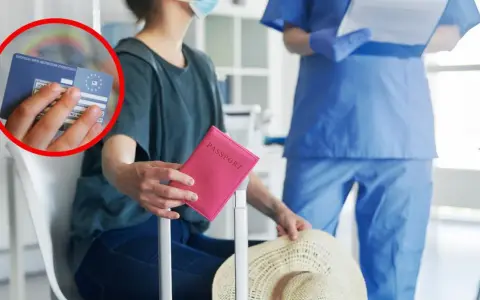 Kobieta w maseczce trzyma różowy paszport i Europejską Kartę Ubezpieczenia Zdrowotnego.