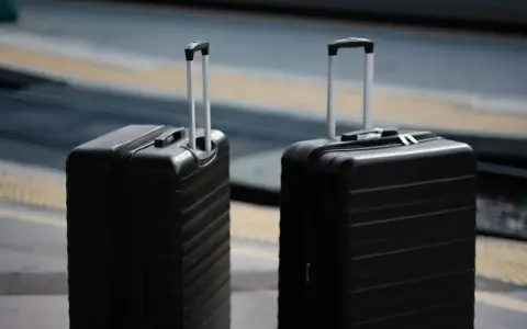 Dwa czarne walizki, idealne jako bagaż podręczny Ryanair, czekają na podróż.