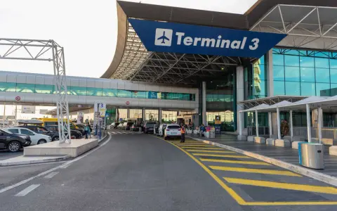 Wejście do Terminalu 3 lotniska Fiumicino z drogą dojazdową i samochodami.