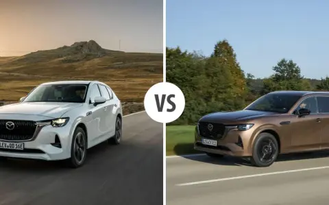 Dwa SUV-y Mazda CX-80: biały i brązowy, z napisem "VS" pośrodku.