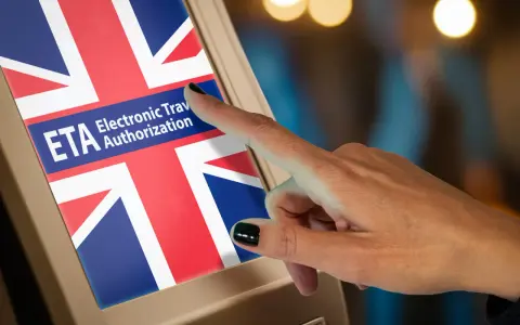 Palec dotyka ekranu z flagą Wielkiej Brytanii i napisem "ETA Electronic Travel Authorization". To krok do uzyskania wizy do Anglii.