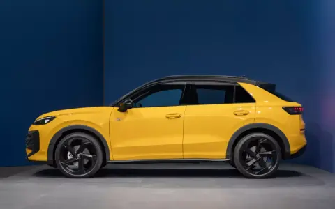 Nowy żółty Volkswagen T-Roc z czarnym dachem, widziany z boku.