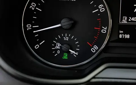 Zbliżenie na deskę rozdzielczą samochodu z wskaźnikiem paliwa CNG.