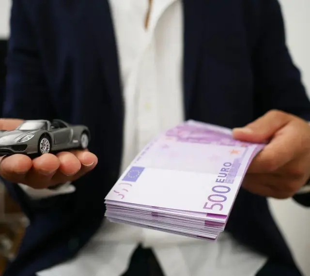 Model samochodu i stos banknotów 500 euro. Symbolizuje to cesję leasingu, gdzie nowy właściciel przejmuje zobowiązania.