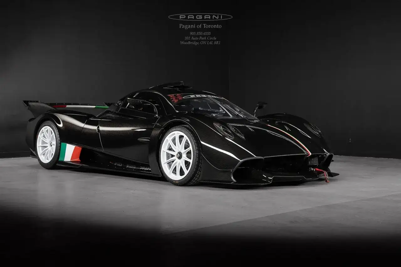 Czarny Pagani Huayra z białymi felgami i włoską flagą na karoserii.