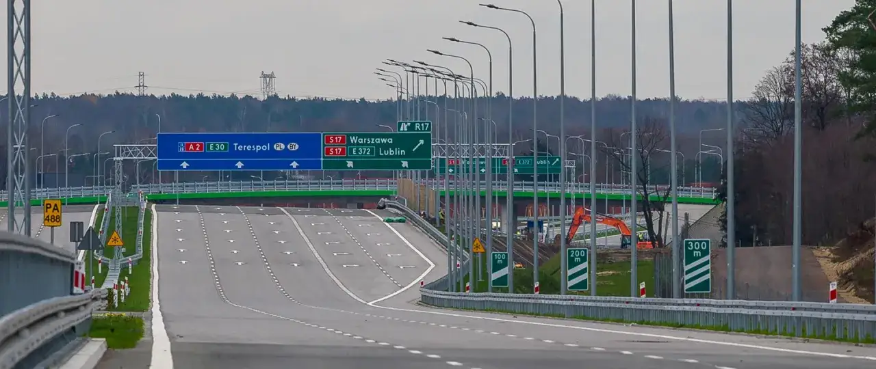 Nowe znaki drogowe wskazują kierunki na Warszawę, Lublin, Terespol. Autostrada w budowie, gotowa na przyjęcie ruchu.