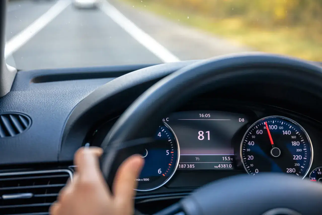 Widok na deskę rozdzielczą samochodu z włączonym tempomatem. Prędkość 81 km/h.