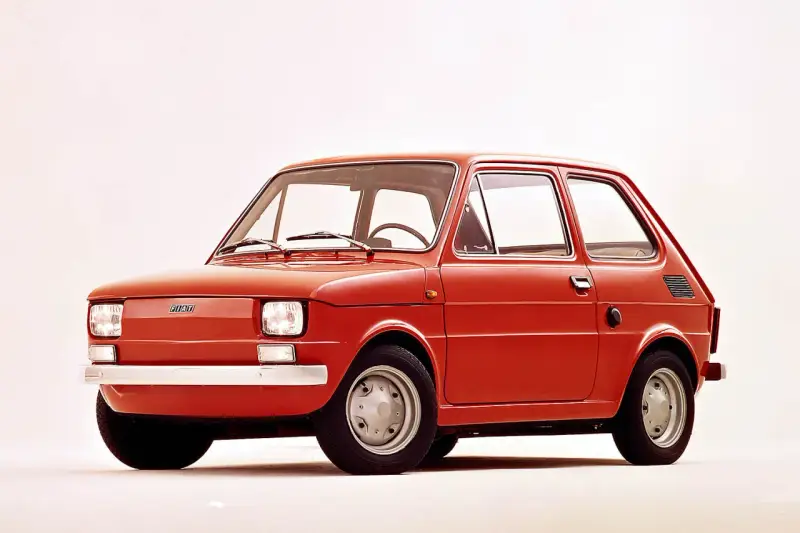 Czerwony polski fiat 126p, ikona motoryzacji, prezentuje się na białym tle.